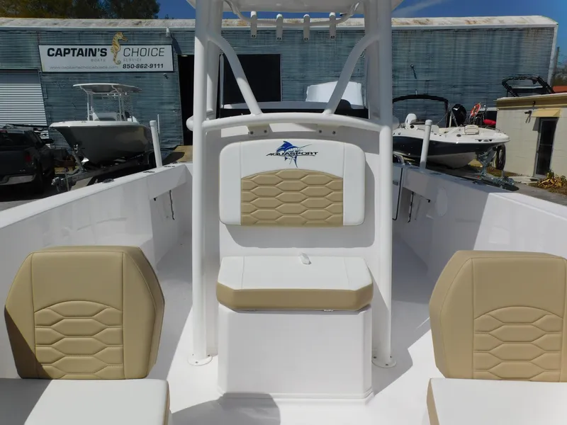 Slide: The Image of 2024 Aquasport 2200 Center Console boat interior with beige seating. - 12