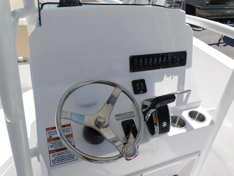 Slide: The Image of 2024 Aquasport 2200 Center Console boat helm with steering wheel and controls. - 20