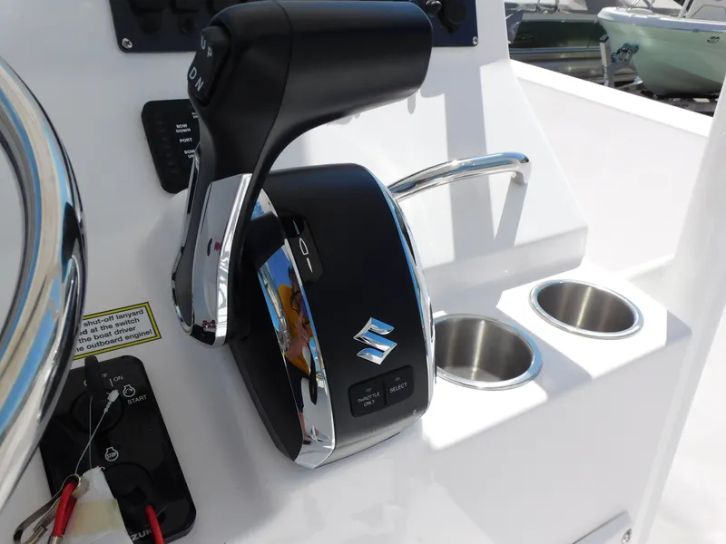 Slide: The Image of 2024 Aquasport 2200 Center Console boat controls and cup holders. - 23