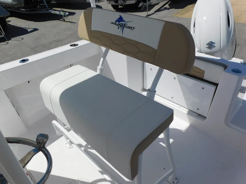 Slide: The Image of 2024 Aquasport 2200 Center Console boat interior with seating and steering wheel. - 27