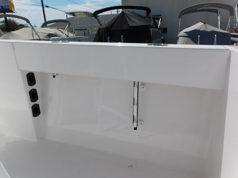 Slide: The Image of 2024 Aquasport 2200 Center Console boat interior, white finish, docked with other boats. - 33
