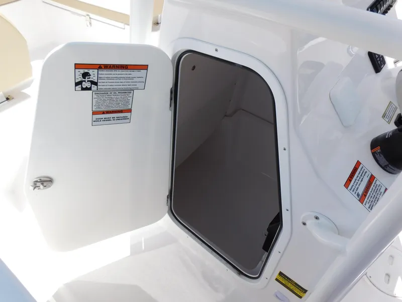 Slide: The Image of 2024 Aquasport 2200 Center Console storage compartment with open door. - 38