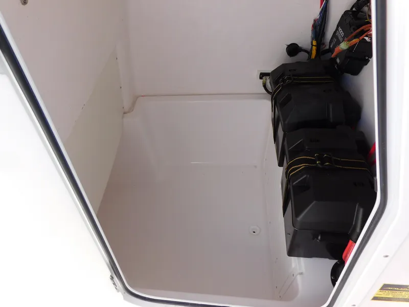 Slide: The Image of 2024 Aquasport 2200 Center Console battery compartment with dual battery setup. - 39