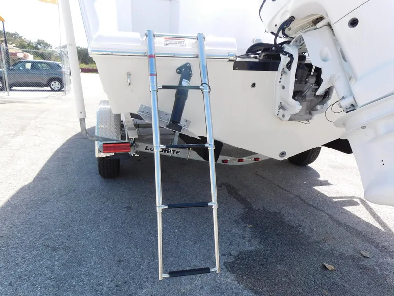 Slide: The Image of 2024 Aquasport 2200 Center Console boat with a foldable ladder on the trailer. - 8