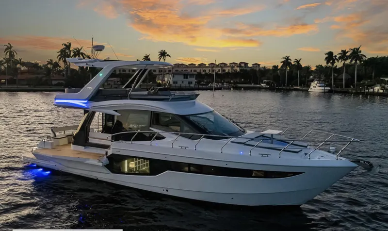 Slide: The Image of 2025 Galeon 500 Fly yacht at sunset on a serene waterfront. - 3