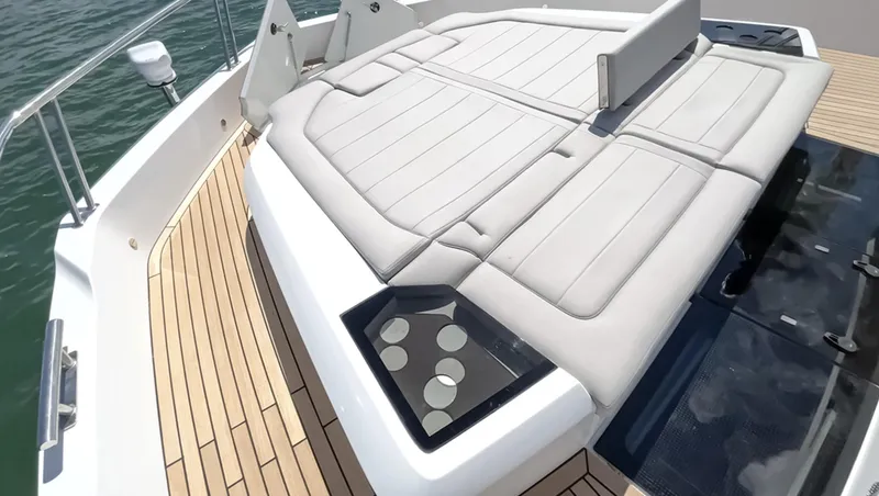 Slide: The Image of 2024 Galeon 560 Fly yacht sun deck with cushioned seating and cup holders. - 5