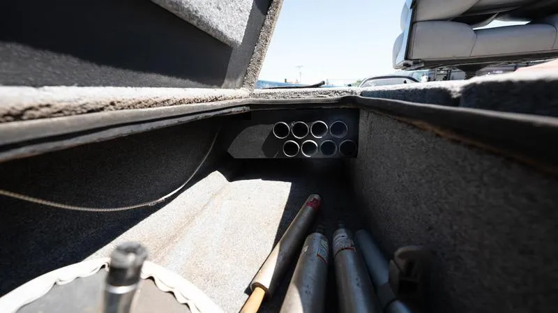 Slide: The Image of Storage compartment of a 2001 Skeeter ZX200 boat with fishing rod holders. - 12