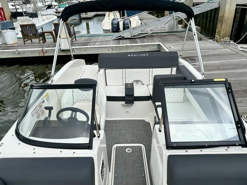 Slide: The Image of 2022 Bayliner DX 2050 boat interior at dock, featuring seating and steering wheel. - 3