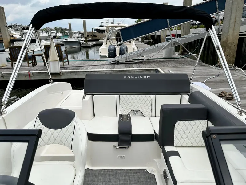 Slide: The Image of 2022 Bayliner DX 2050 boat interior with seating, docked at marina. - 6