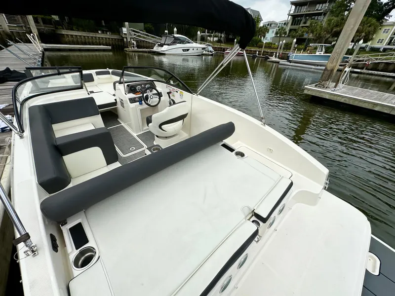 Slide: The Image of 2022 Bayliner DX 2050 boat docked, featuring spacious seating and modern design. - 7