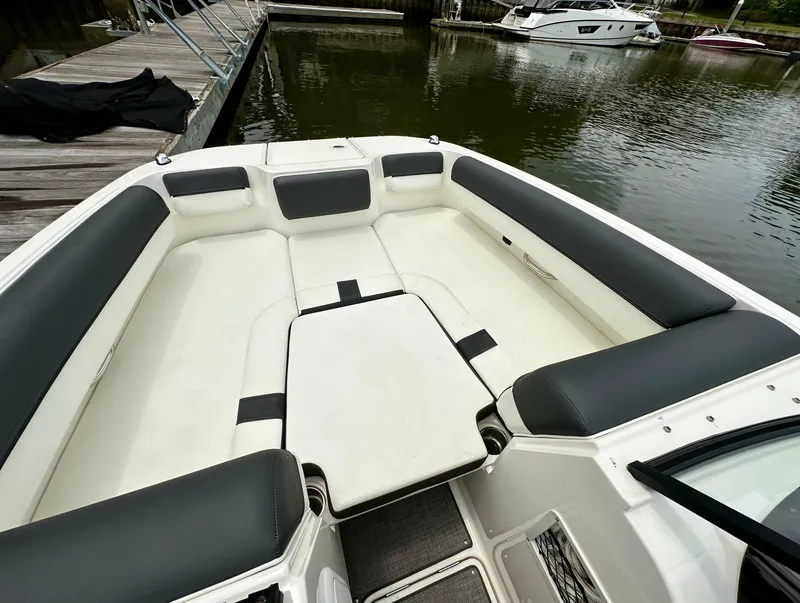 Slide: The Image of Bayliner DX 2050 boat interior, 2022 model, featuring spacious seating and sleek design at a dock. - 8