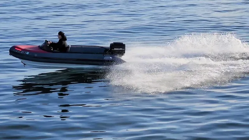 Slide: The Image of Person driving a small motorboat on calm water, creating a wake. - 23