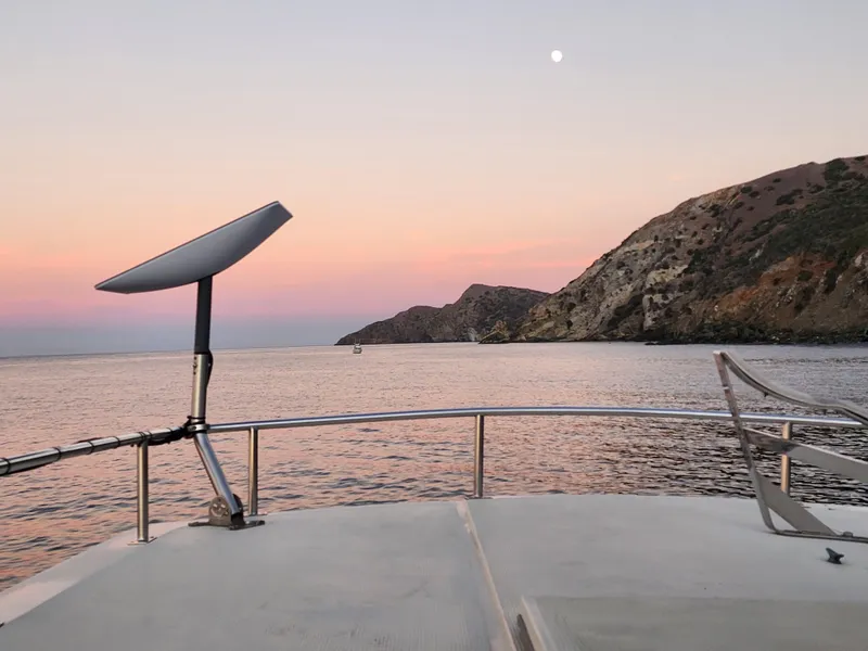 Slide: The Image of View from 1987 Hi-Star Yacht Fisher 55 at sunset with coastal cliffs and calm sea. - 25