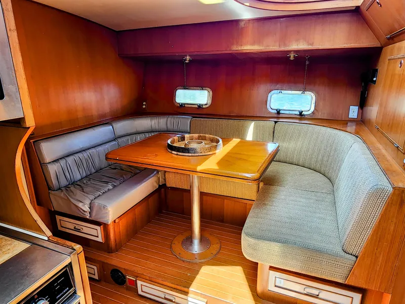 Slide: The Image of 1987 Hi-Star Yacht Fisher 55 interior dining area with wooden table and cushioned seating. - 30