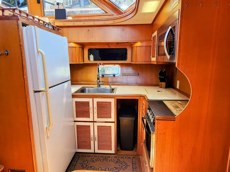Slide: The Image of 1987 Hi-Star Yacht Fisher 55 kitchen with wooden cabinetry, white appliances, and skylight. - 31