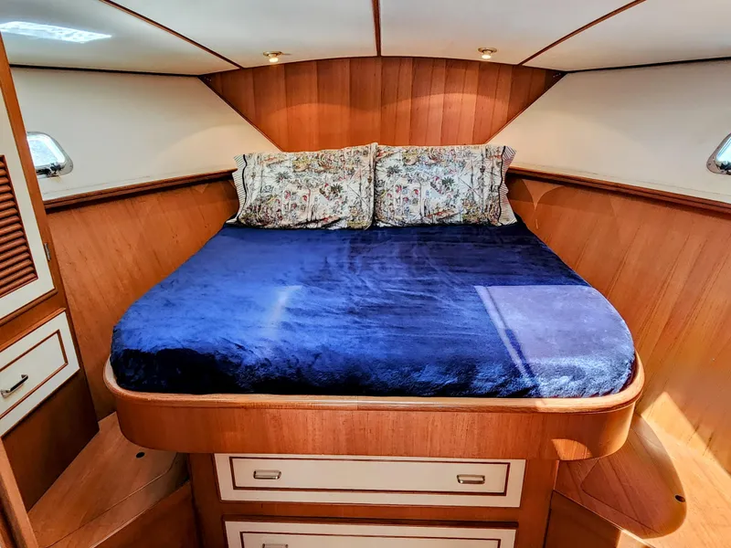 Slide: The Image of 1987 Hi-Star Yacht Fisher 55 bedroom with blue bedding and wooden interior. - 35