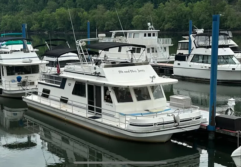 The Image of 1990 Gibson 50 Classic houseboat docked in a marina, surrounded by other boats. - 1