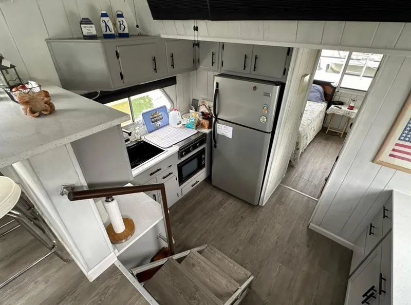 Slide: The Image of Compact kitchen in a 1990 Gibson 50 Classic boat, featuring modern appliances and cozy interior design. - 11