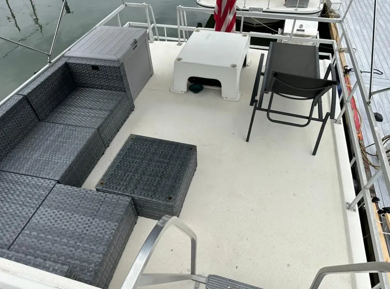 Slide: The Image of Upper deck of a 1990 Gibson 50 Classic boat with outdoor seating and table. - 4