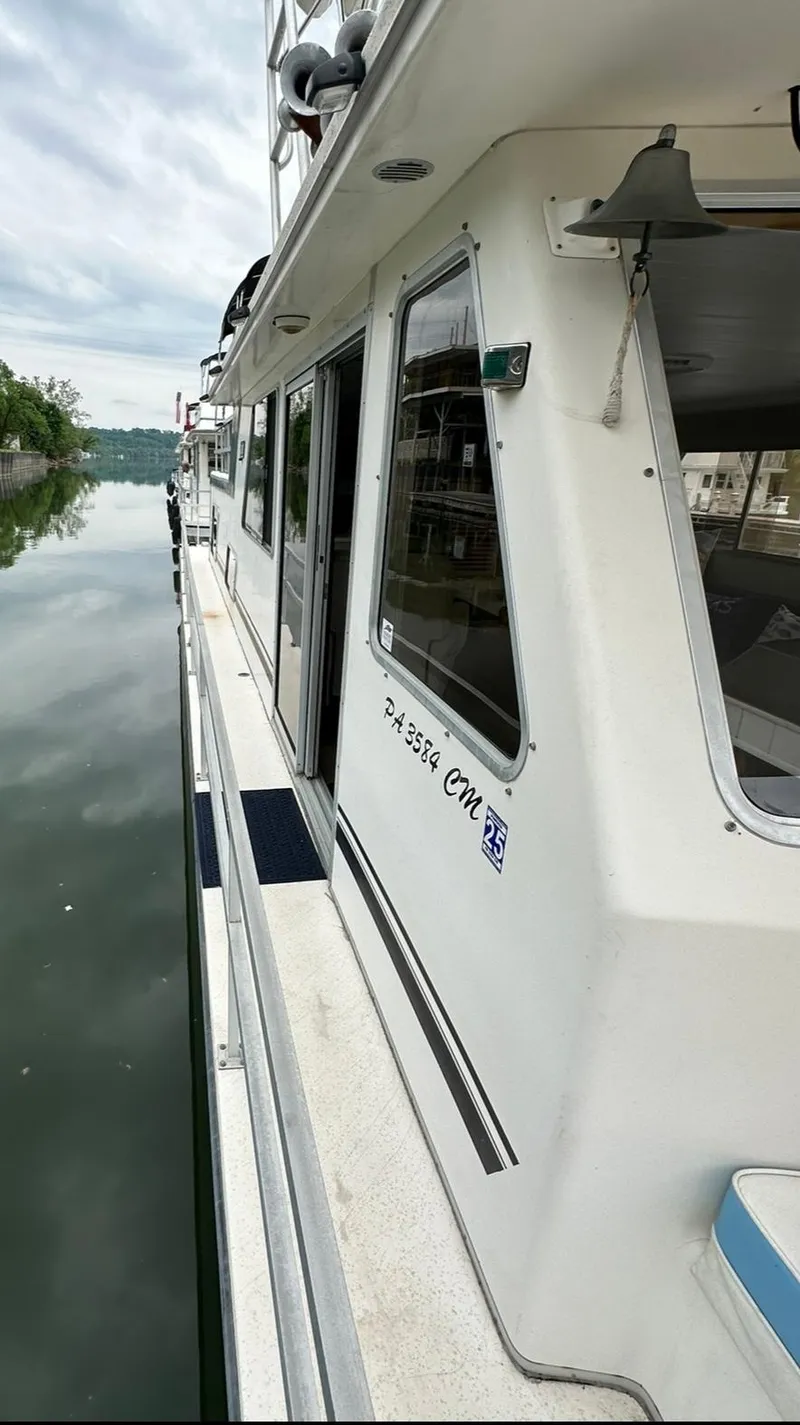 Slide: The Image of 1990 Gibson 50 Classic boat docked on calm water, side view. - 7
