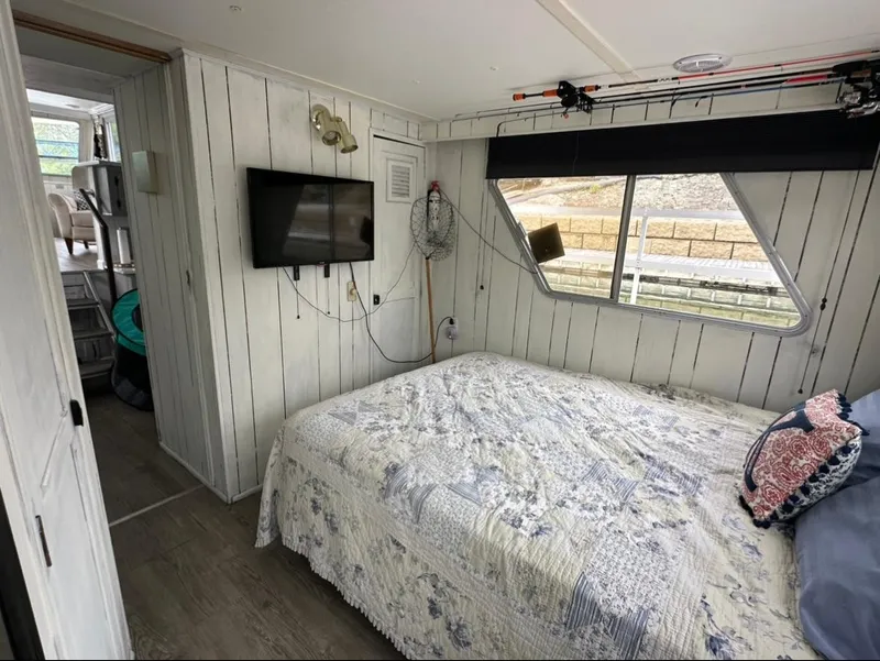 Slide: The Image of Cozy bedroom in a 1990 Gibson 50 Classic boat with a TV and window view. - 8