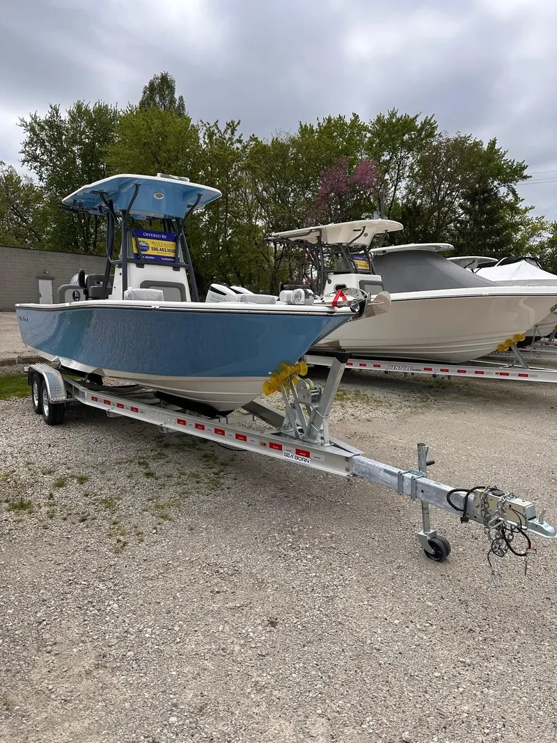 The Image of 2024 Sea Born LX24 Center Console boat on a trailer in a lot. - 0