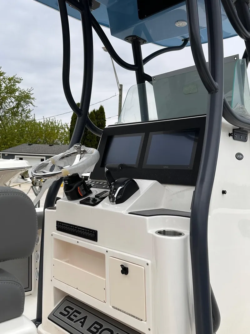 Slide: The Image of 2024 Sea Born LX24 Center Console boat dashboard with dual screens and steering wheel. - 3