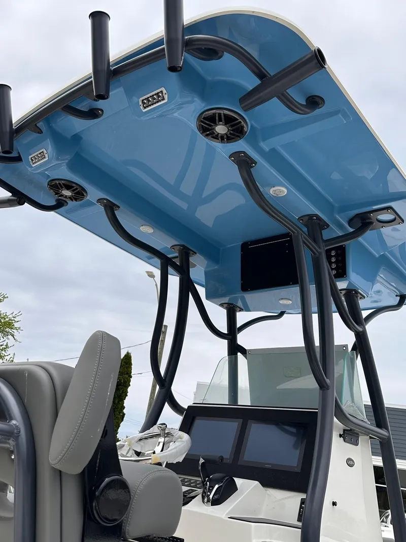 Slide: The Image of 2024 Sea Born LX24 Center Console boat with blue T-top and modern controls. - 5