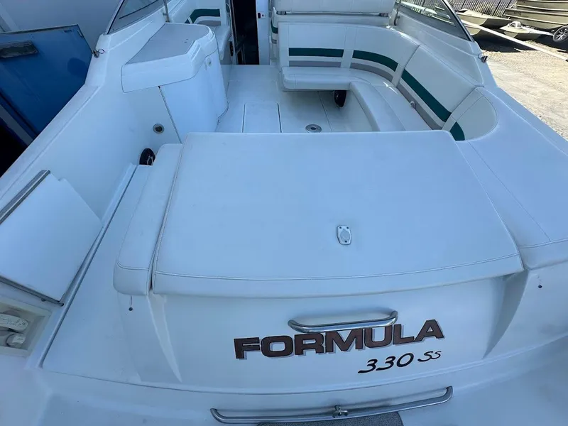 Slide: The Image of 1999 Formula 330 SS boat interior with white seating and green accents. - 11