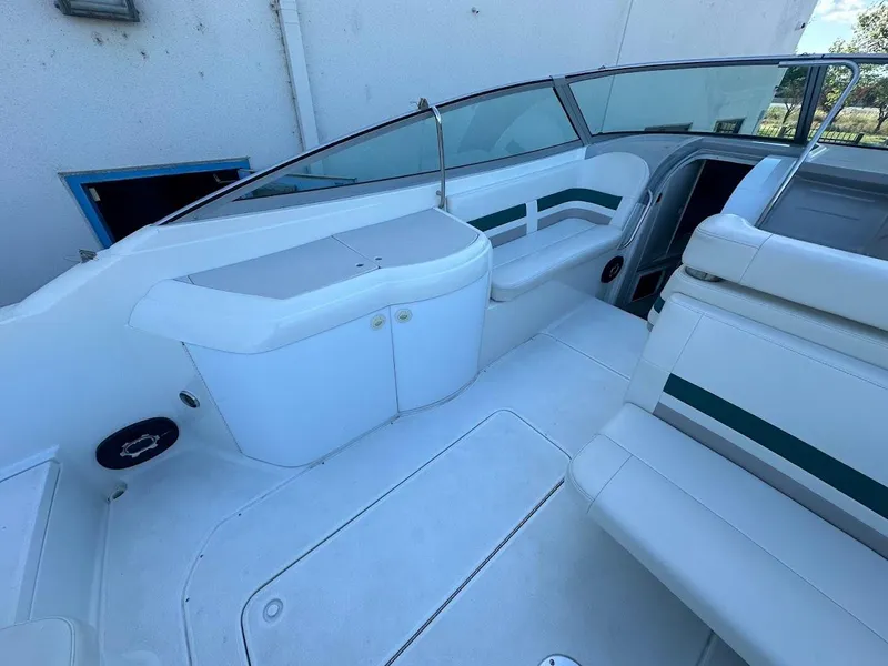 Slide: The Image of 1999 Formula 330 SS boat interior with white seating and storage compartments. - 16