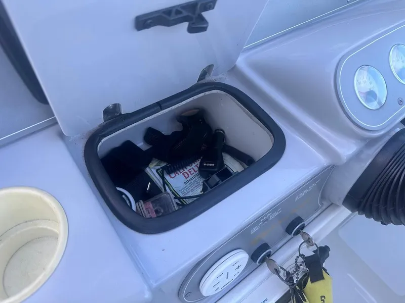 Slide: The Image of Storage compartment on a 1999 Formula 330 SS boat dashboard with various items inside. - 27