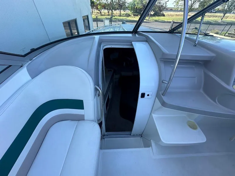 Slide: The Image of 1999 Formula 330 SS boat interior with white seating and cabin entrance. - 32