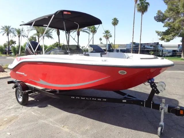 The Image of 2023 Bayliner Element M17 boat with red hull on trailer, parked outdoors. - 1
