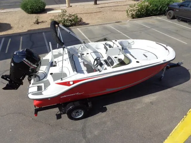 Slide: The Image of 2023 Bayliner Element M17 boat in red and white, parked on a trailer. - 15
