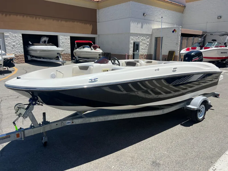The Image of 2023 Bayliner Element E18 boat on a trailer in a dealership lot. - 1