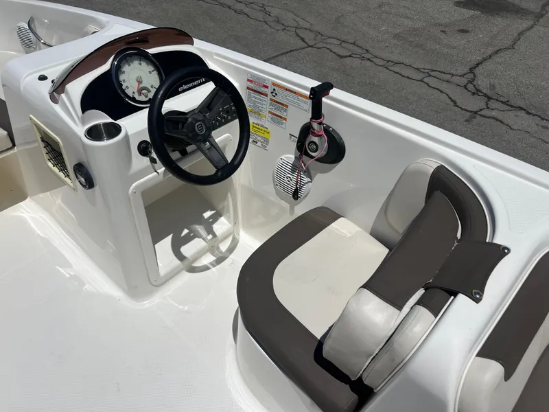 Slide: The Image of 2023 Bayliner Element E18 boat cockpit with steering wheel and seating. - 10