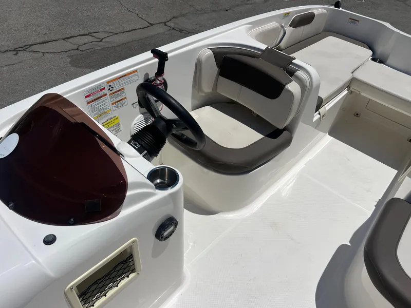 Slide: The Image of 2023 Bayliner Element E18 boat interior with steering wheel and seating. - 14