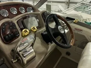 Slide: The Image of 2005 Sea Ray 320 Sundancer helm with steering wheel and control panel. - 12