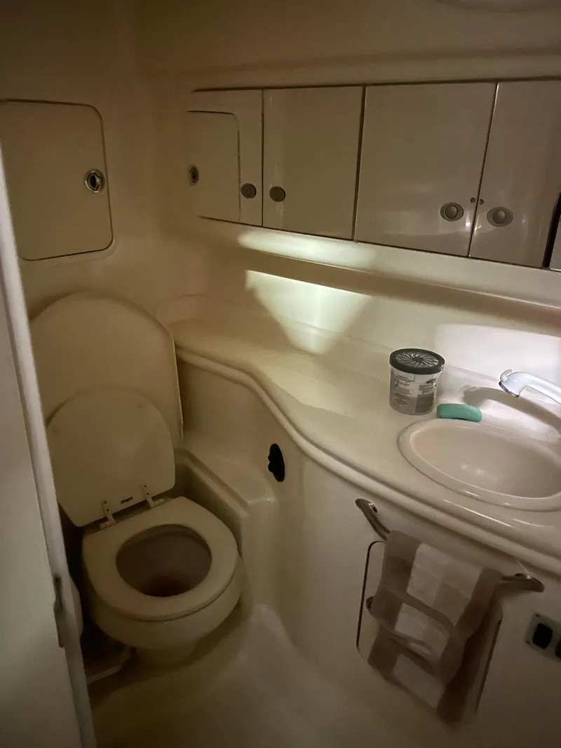 Slide: The Image of 2005 Sea Ray 320 Sundancer bathroom with toilet, sink, and storage cabinets. - 6