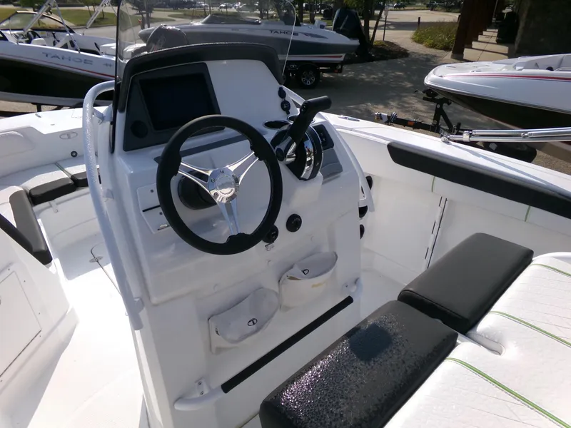 Slide: The Image of 2024 Tahoe 2150 CC boat interior with steering wheel and control panel. - 2