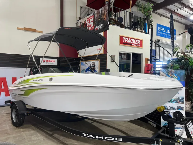 The Image of 2024 Tahoe T18 boat on display in showroom with canopy and trailer. - 0