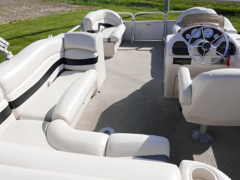 Slide: The Image of 2008 Manitou Oasis pontoon boat interior with white seating and steering console. - 11
