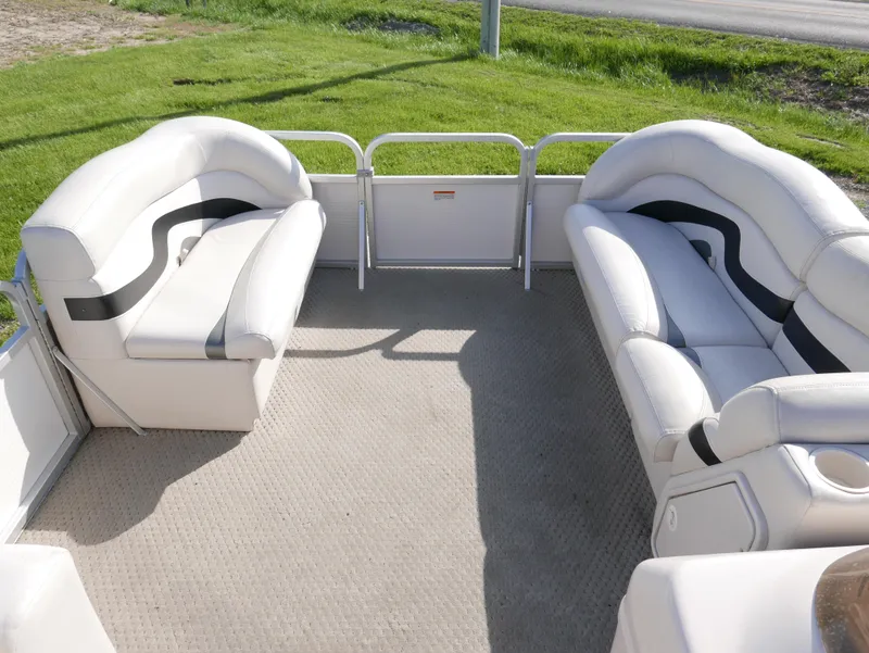Slide: The Image of 2008 Manitou Oasis pontoon boat interior with white cushioned seating. - 5