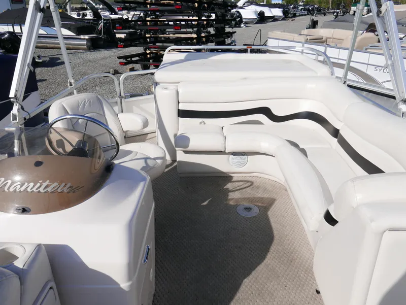 Slide: The Image of 2008 Manitou Oasis pontoon boat interior with beige seating and helm. - 6