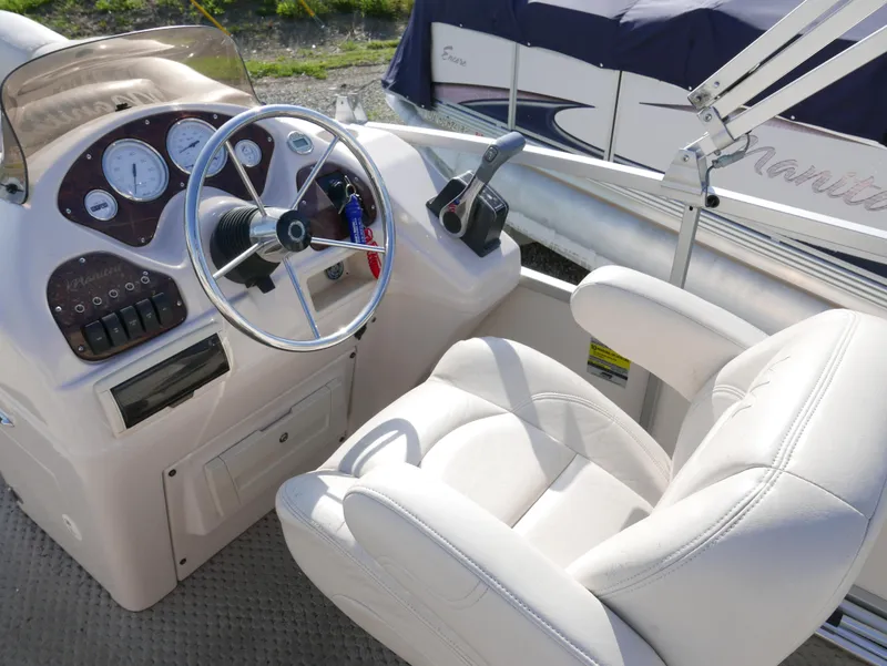 Slide: The Image of 2008 Manitou Oasis boat cockpit with steering wheel and control panel. - 7