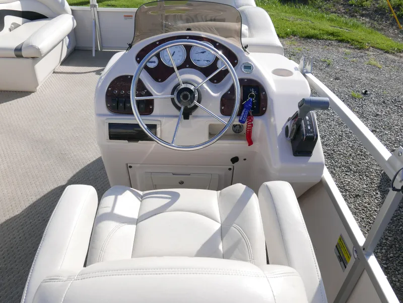 Slide: The Image of 2008 Manitou Oasis boat dashboard with steering wheel and controls. - 8