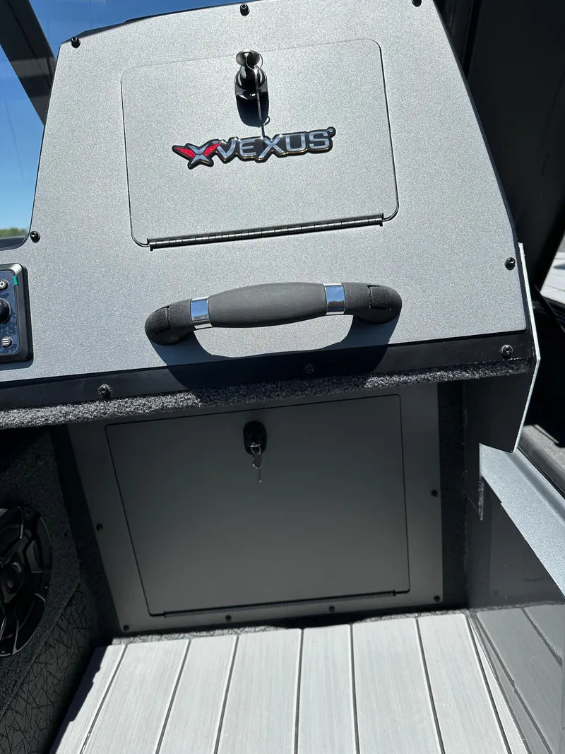 Slide: The Image of 2024 Vexus ADX180 boat console with storage compartments and Vexus logo. - 14