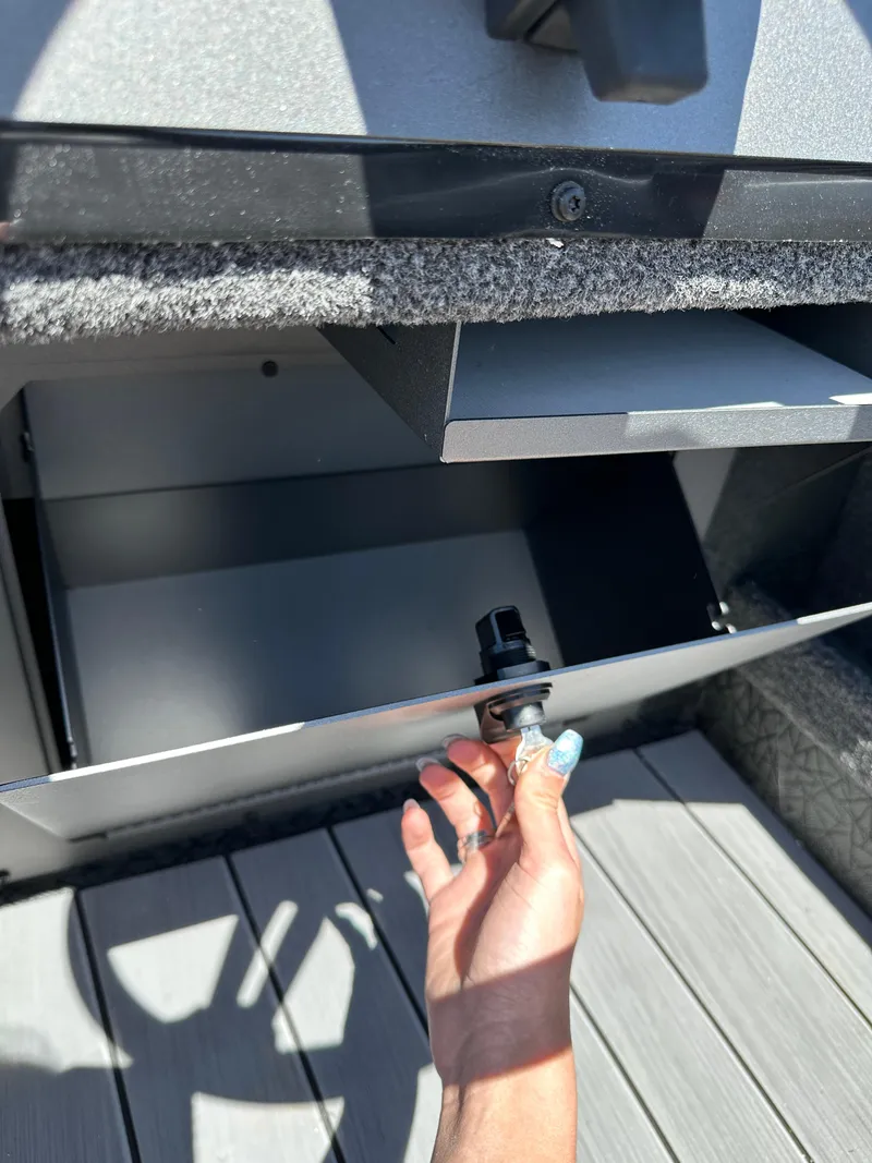 Slide: The Image of Hand opening storage compartment on 2024 Vexus ADX180 boat. - 17