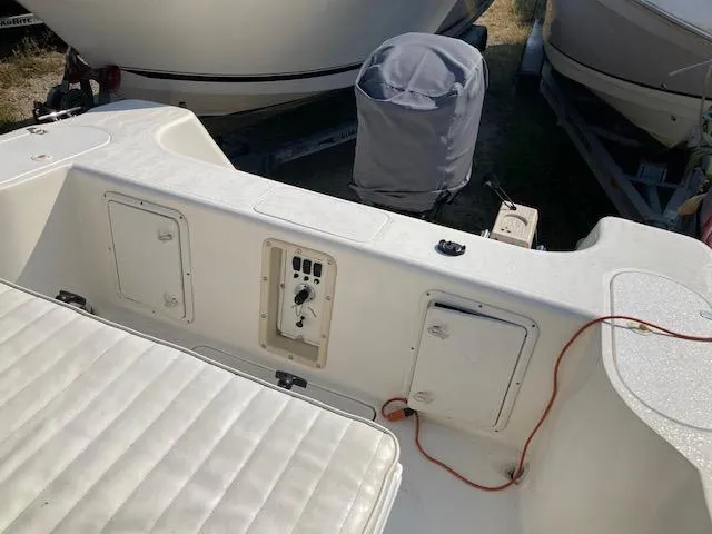 Slide: The Image of 1998 Century 2300 Center Console boat interior with storage compartments and control panel. - 16