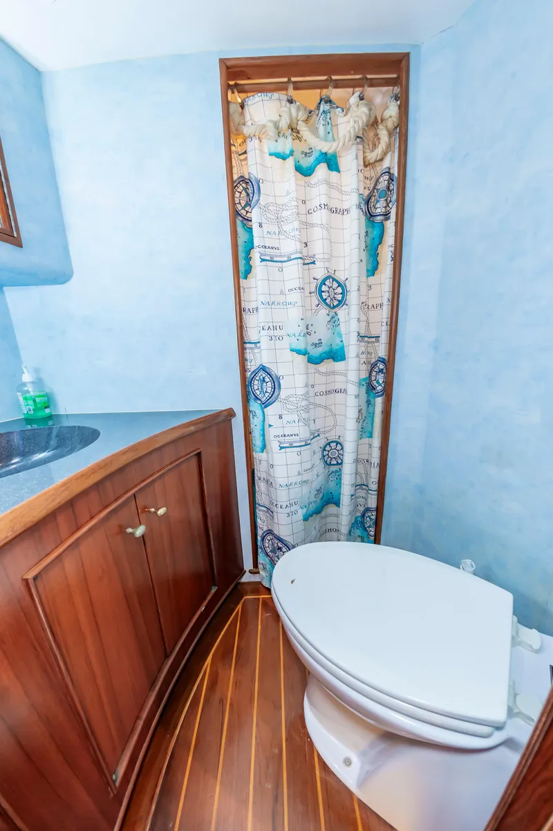 Slide: The Image of 1993 Jarrett Bay Convertible bathroom with nautical-themed shower curtain and wooden cabinetry. - 40
